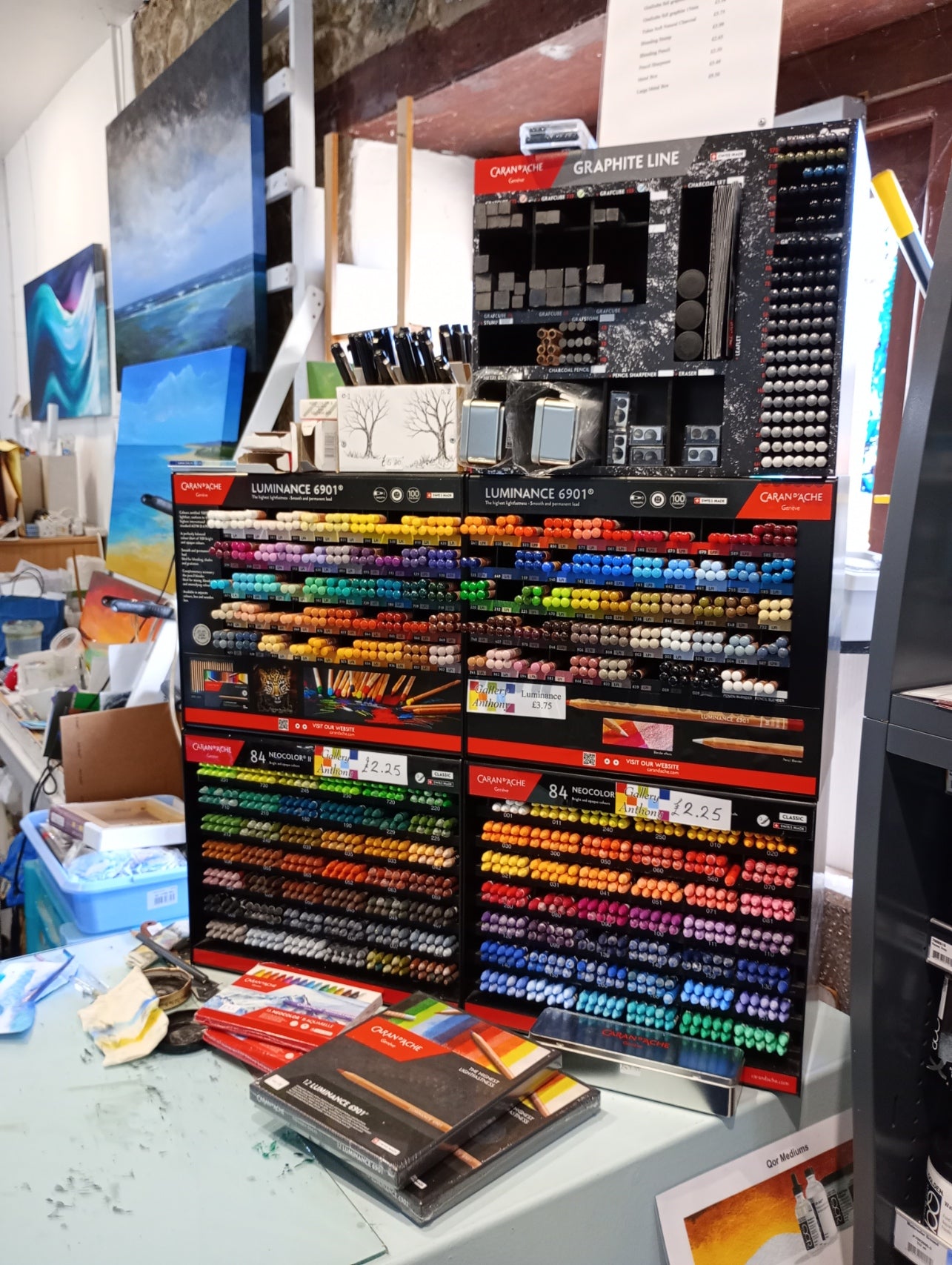 Display of art supplies including Neocolor 2 watersoluable crayons and pencils in a store setting.