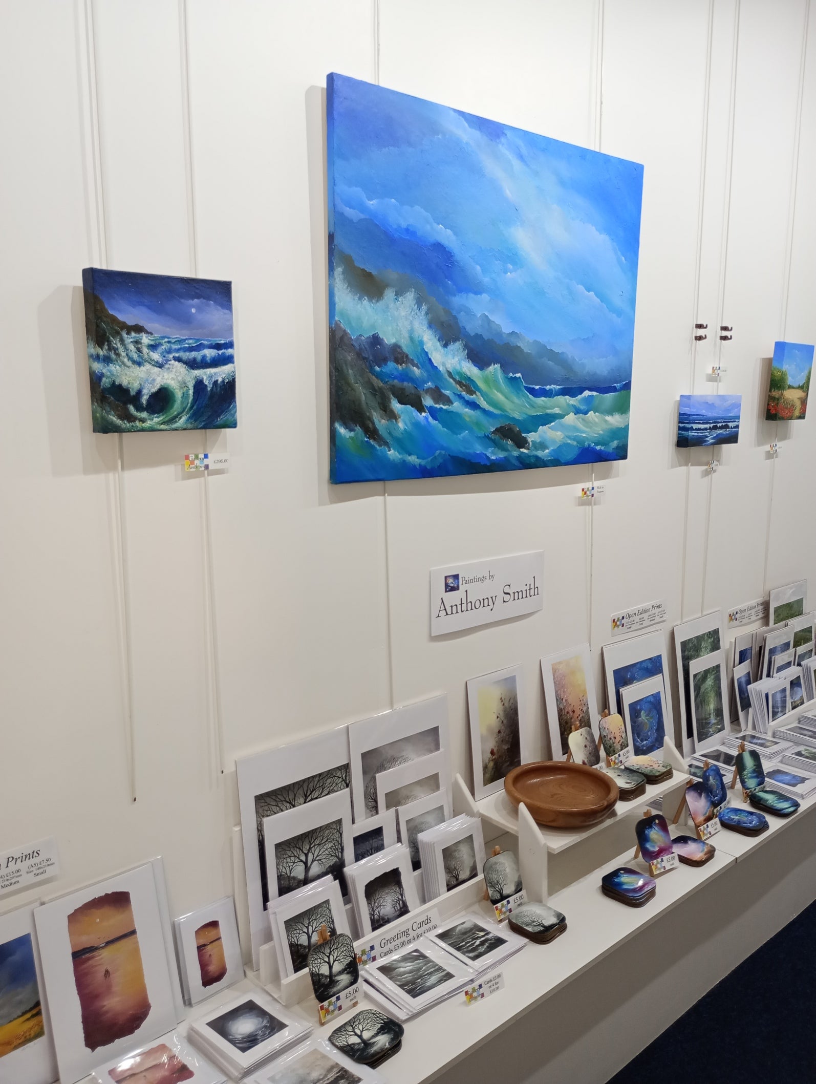 Art gallery with various artworks on display, including a large blue wave painting.